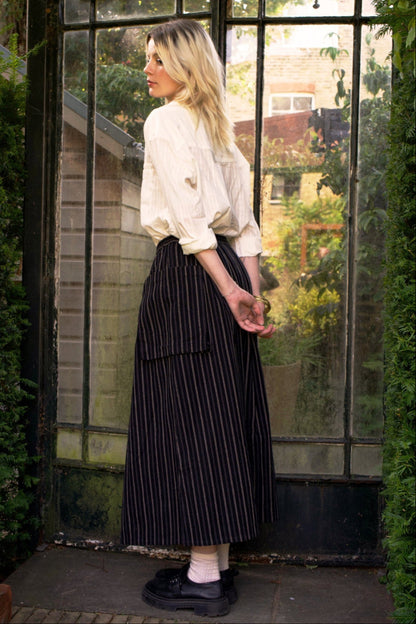 Woman standing in front of a large glass door with a garden view.