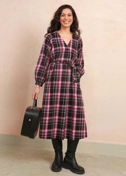 Close-up shot focusing on the flattering wrap front, V-neckline, and matching fabric tie belt of the Amelia Dress