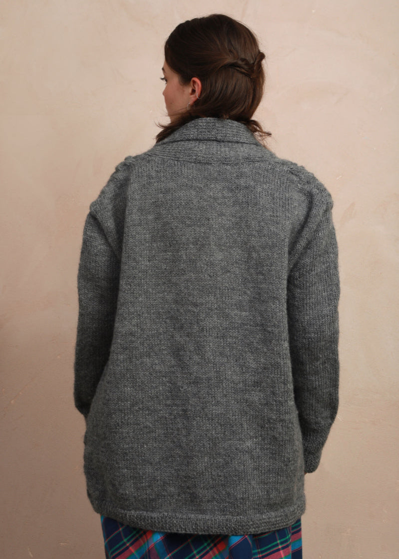 Back view of model wearing the natural charcoal grey hand-knit longline cardigan