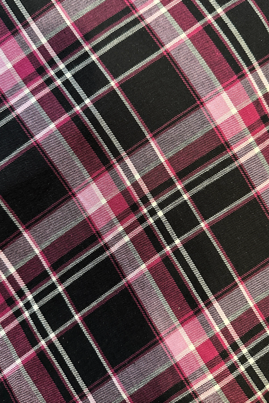 A close-up of a plaid fabric pattern with black, pink, white, and gray stripes.