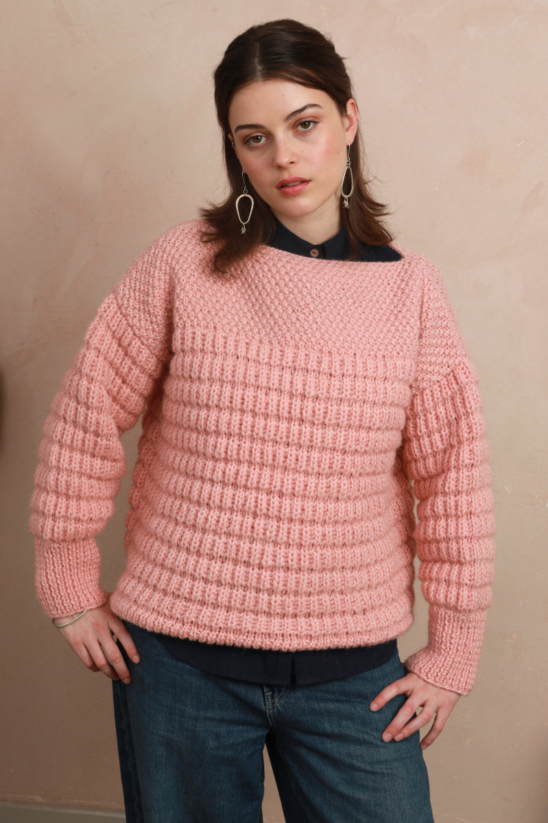 Model wearing the candyfloss pink boat neck sweater with hands on hips showing relaxed silhouette