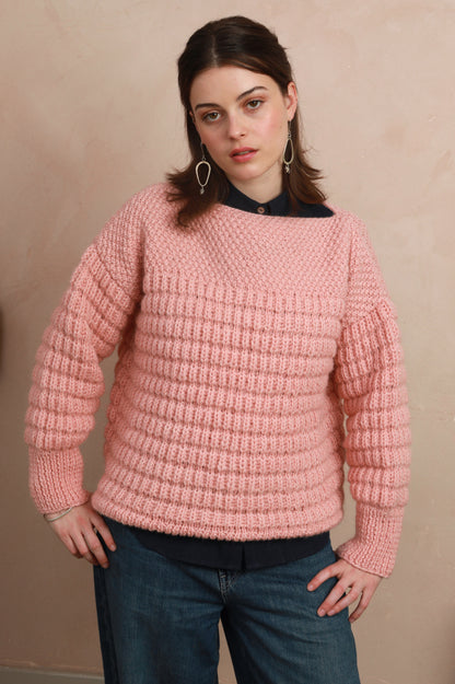 Model wearing the candyfloss pink boat neck sweater with hands on hips showing relaxed silhouette