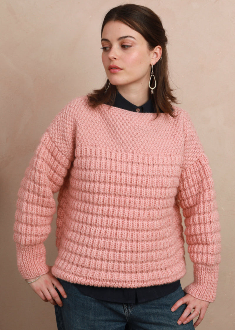 Model wearing the candyfloss pink hand-knit boat neck sweater layered over a collared shirt