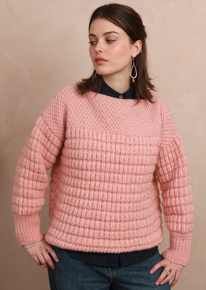 Model wearing the candyfloss pink hand-knit boat neck sweater layered over a collared shirt