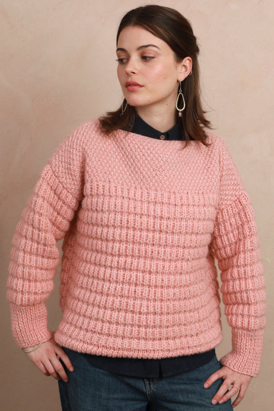 Model wearing the candyfloss pink hand-knit boat neck sweater layered over a collared shirt