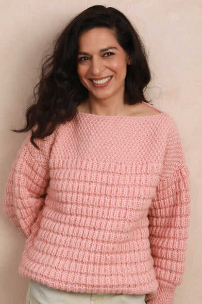 Full-length view of model standing in the candyfloss pink hand-knit sweater