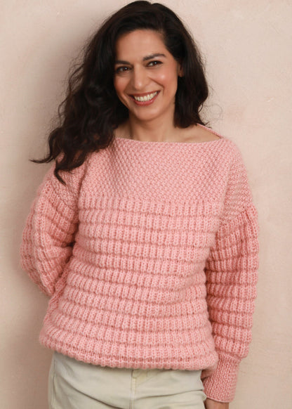 Full-length view of model standing in the candyfloss pink hand-knit sweater