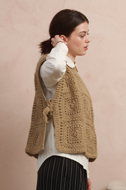 Side profile view of model wearing the boxy natural corn yellow crochet square vest showing tie detail
