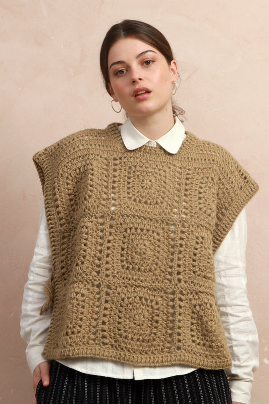 Model wearing the natural corn yellow hand-crocheted square vest layered over a white collared shirt