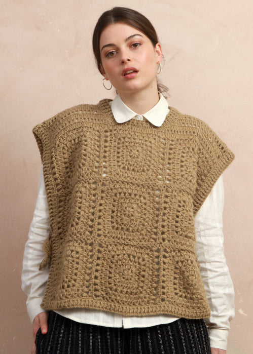Model wearing the natural corn yellow hand-crocheted square vest layered over a white collared shirt