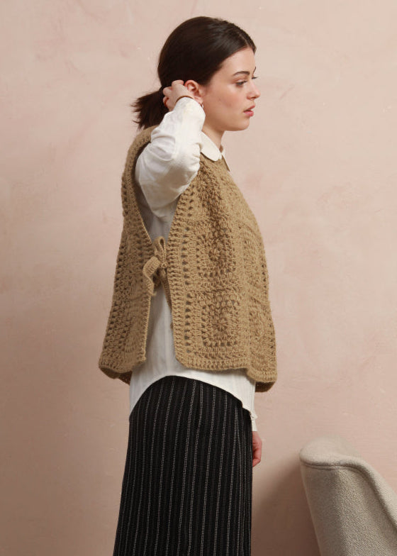 Side profile view of model wearing the boxy natural corn yellow crochet square vest showing tie detail