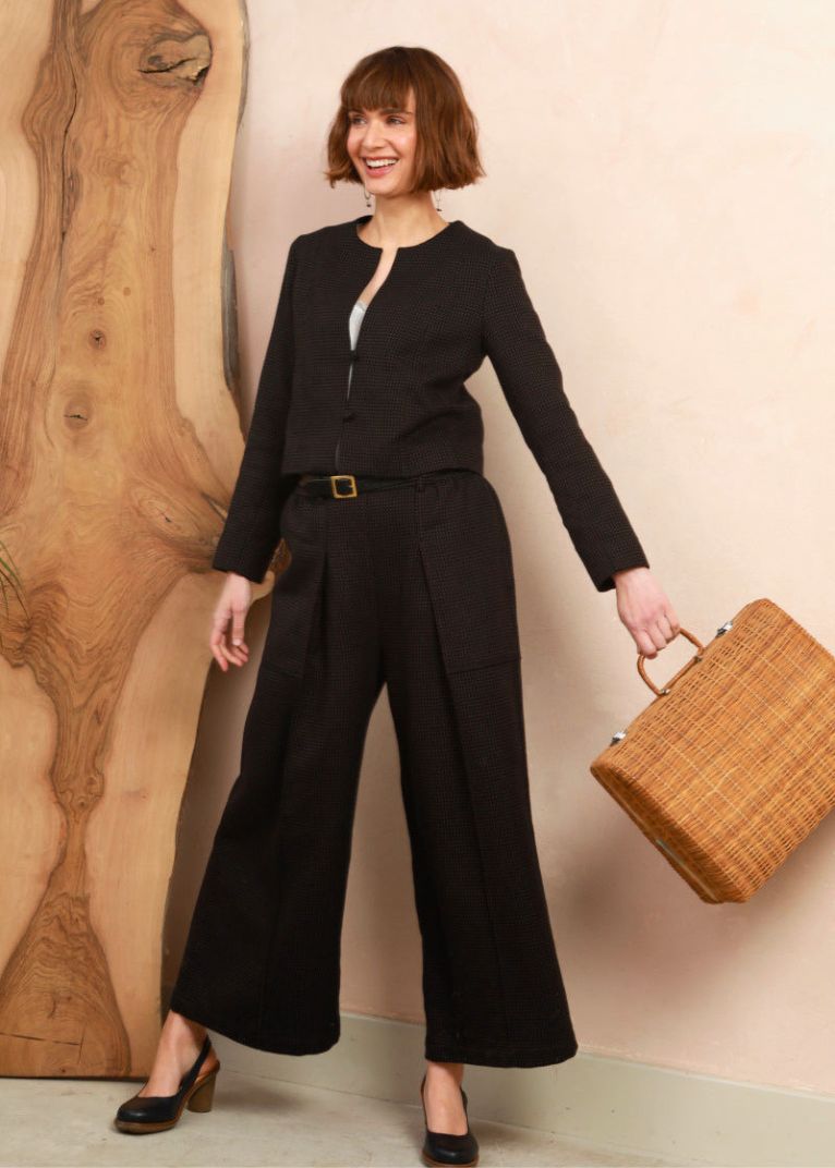 Model wearing the cropped collarless jacket in black and brown handwoven jacquard weave