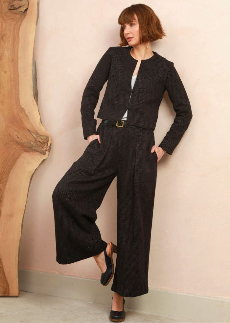 Model wearing the cropped collarless jacket in black and brown handwoven jacquard weave