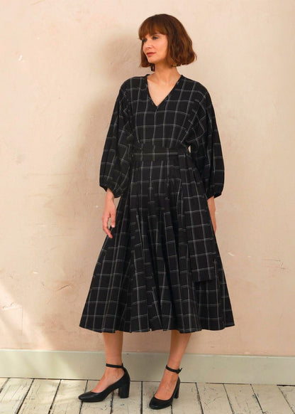 Model wearing the black and white check Penny Dress styled with black heels