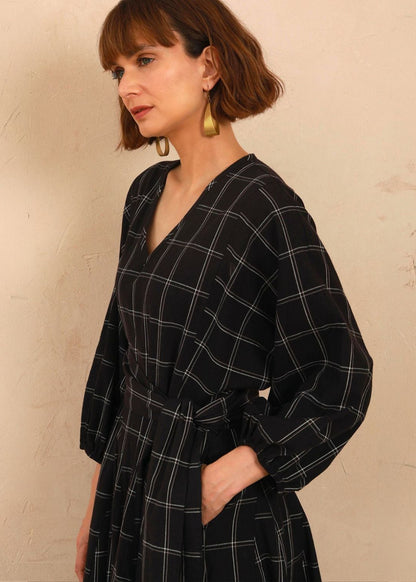 Close-up view of model with hand in the functional side pocket of the black and white check Penny Dress