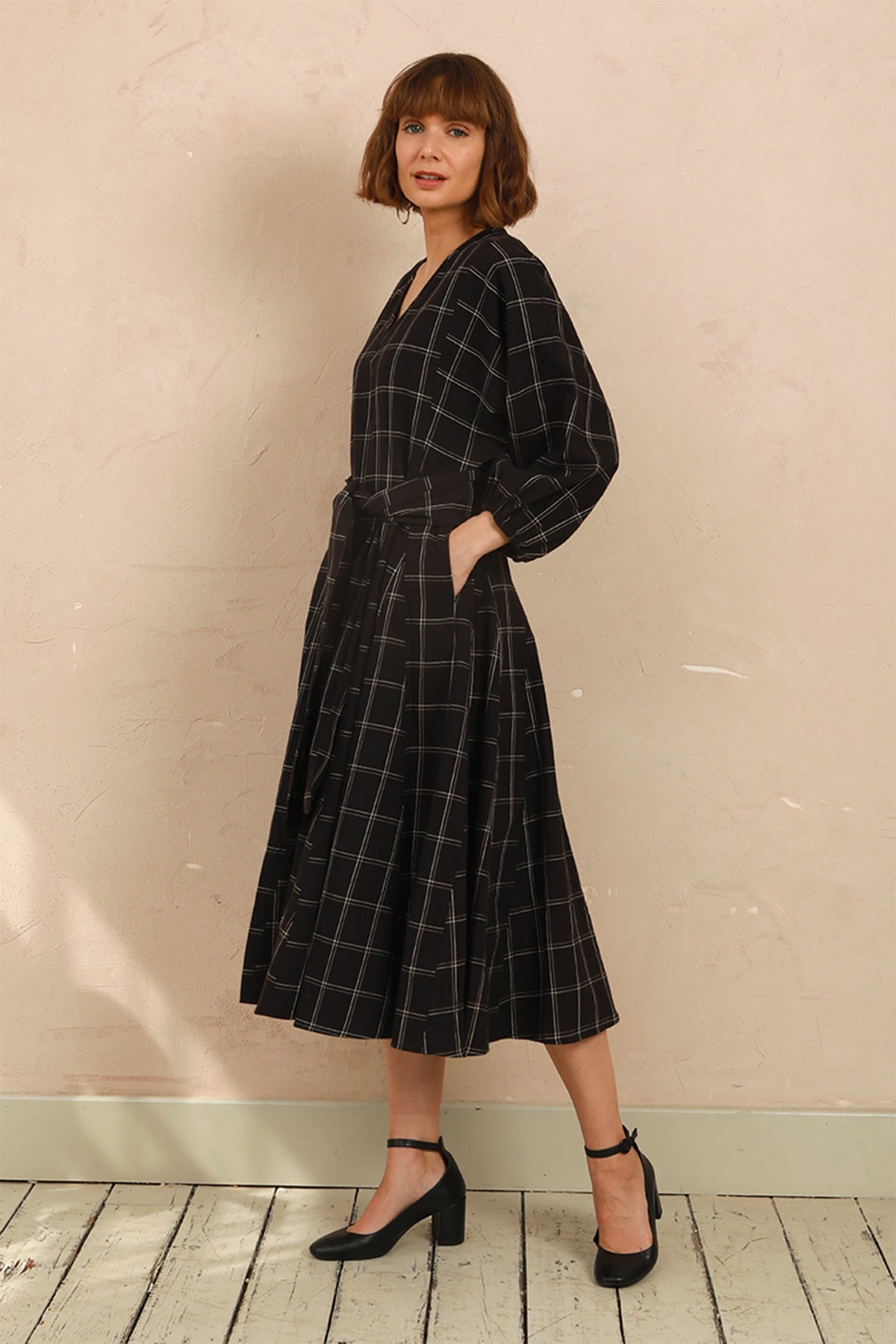 Model wearing the black and white check Penny Dress styled with black heels