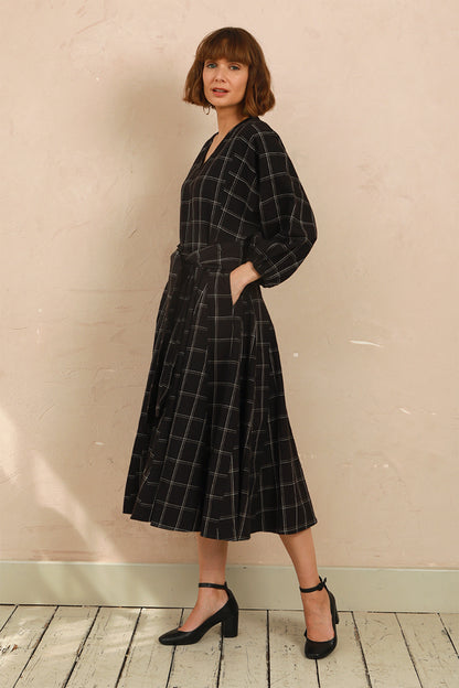Model wearing the black and white check Penny Dress styled with black heels
