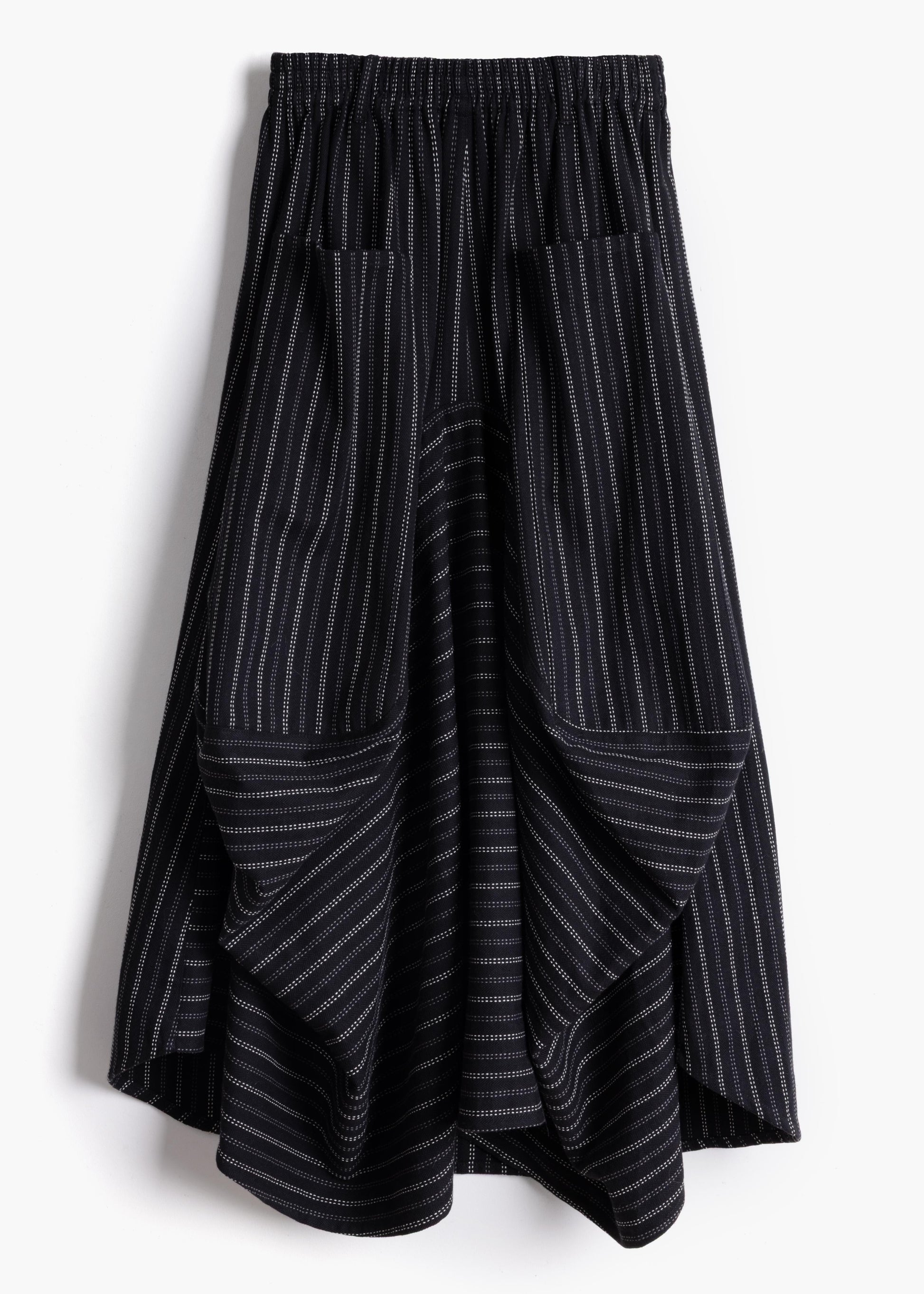 Studio product shot of the black stripe Safia Skirt showing asymmetrical draped hem and pinstripe pattern