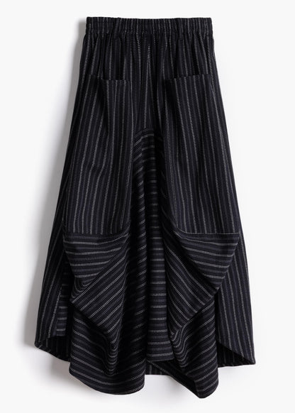 Studio product shot of the black stripe Safia Skirt showing asymmetrical draped hem and pinstripe pattern