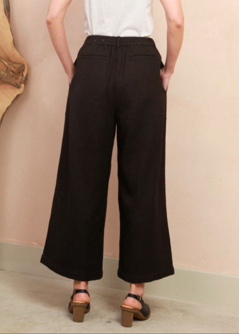 Back view of model wearing the black and brown jacquard Sarah Trousers showing waistband fit and back pocket detail
