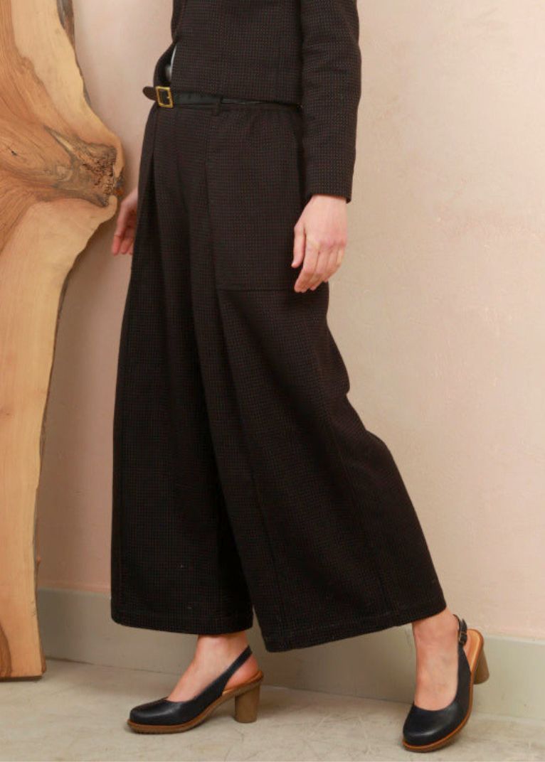 Side profile shot of model wearing the black and brown jacquard Sarah Trousers demonstrating fluid movement