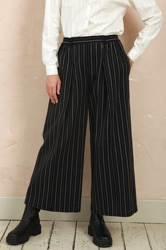 Front view of model wearing the black stripe Sarah Trousers with wide-leg silhouette and front pleats