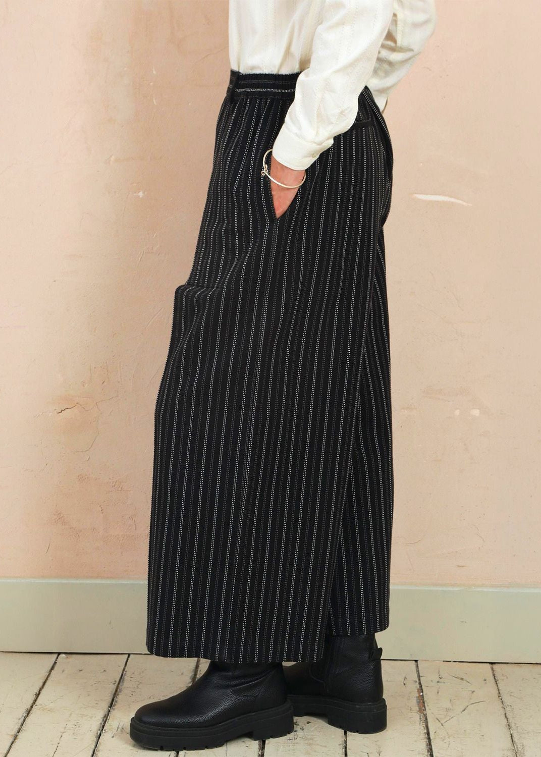 Model stood in the black stripe Sarah Trousers showing the fluid drape and wide-leg movement