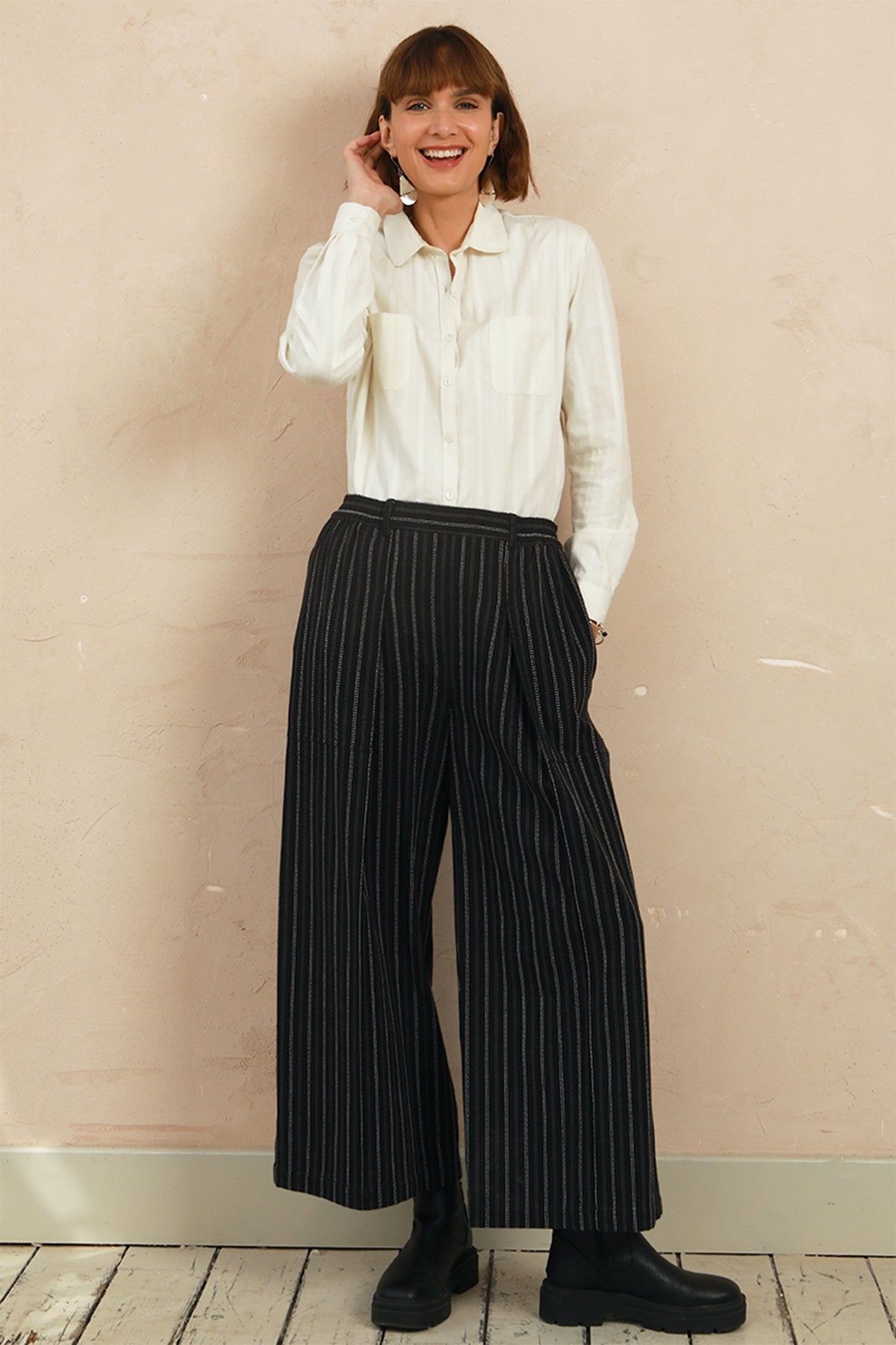 Full-length view of model wearing the black stripe Sarah Trousers styled with a white top