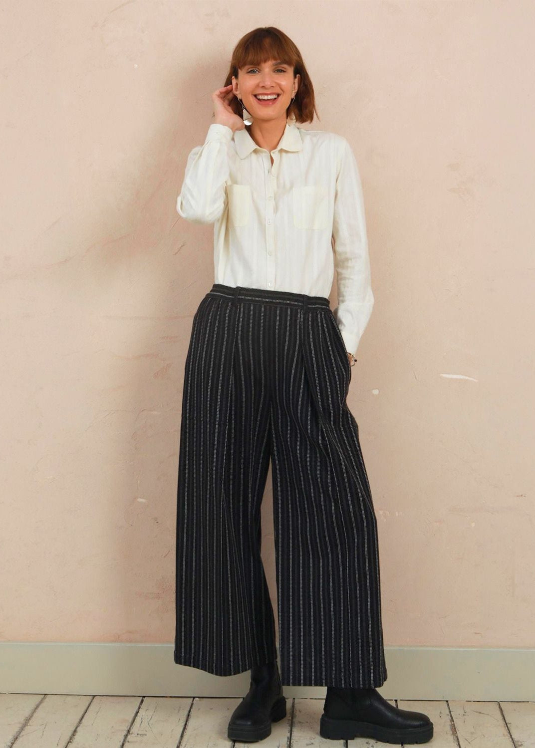 Full-length view of model wearing the black stripe Sarah Trousers styled with a white top