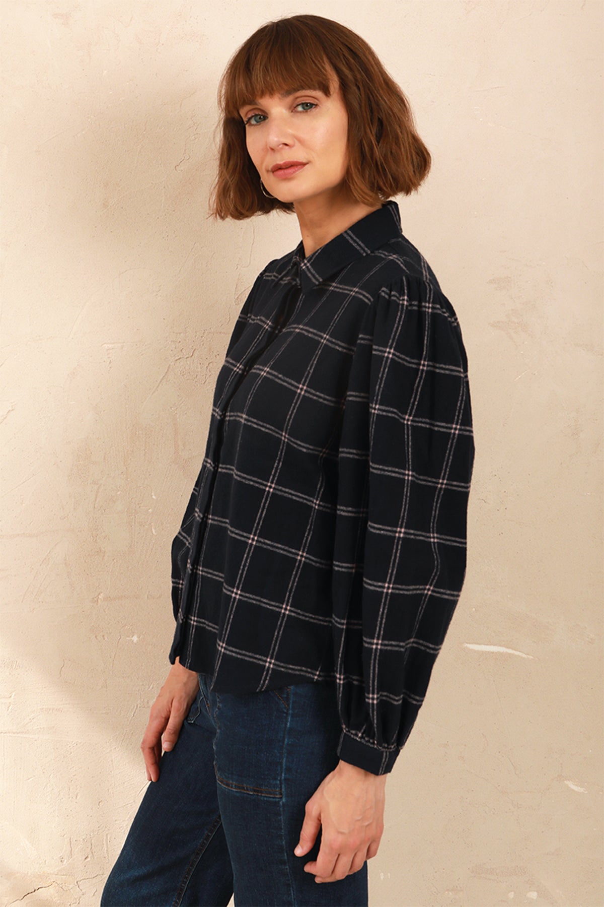 Model wearing the navy and pink Effie Blouse with volume sleeves, side view