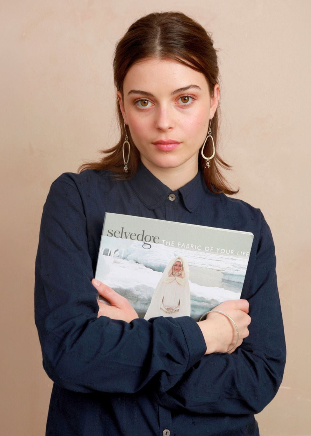 Model holding a magazine while wearing the deep navy Sylvia Shirt