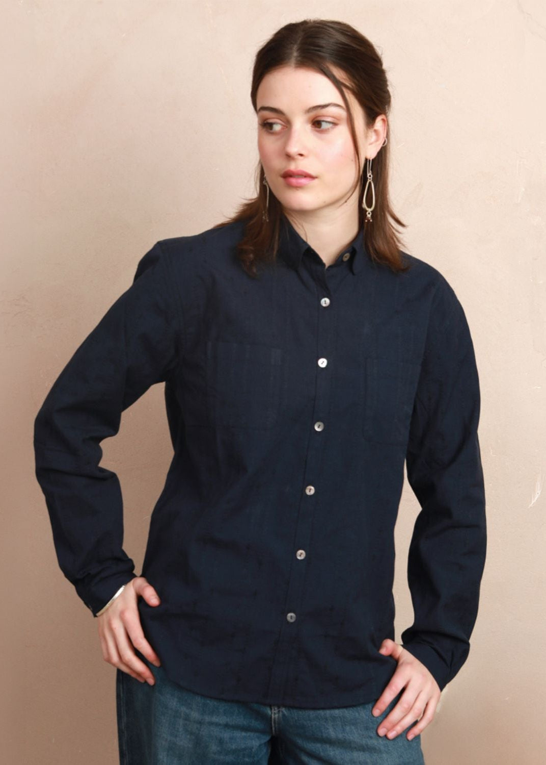 Model wearing the deep navy Sylvia Shirt with rounded collar and hands on hips