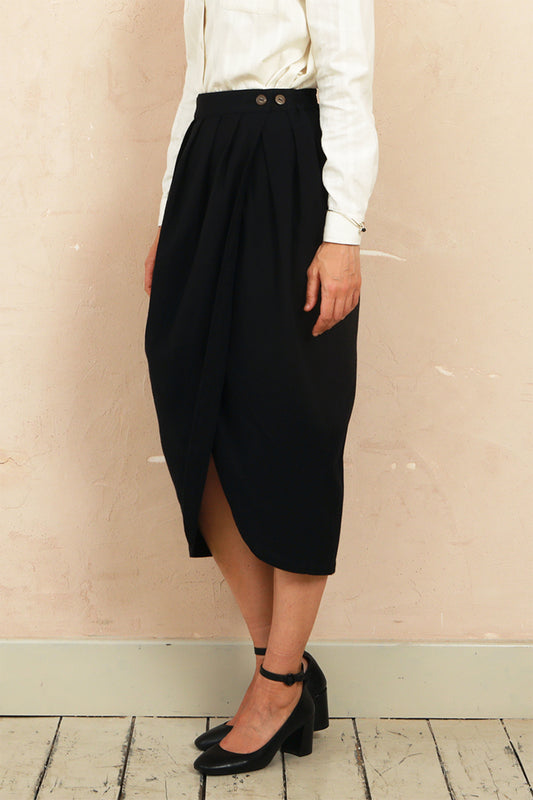 Side profile view of model wearing the black Venus Skirt showing the midi length and silhouette