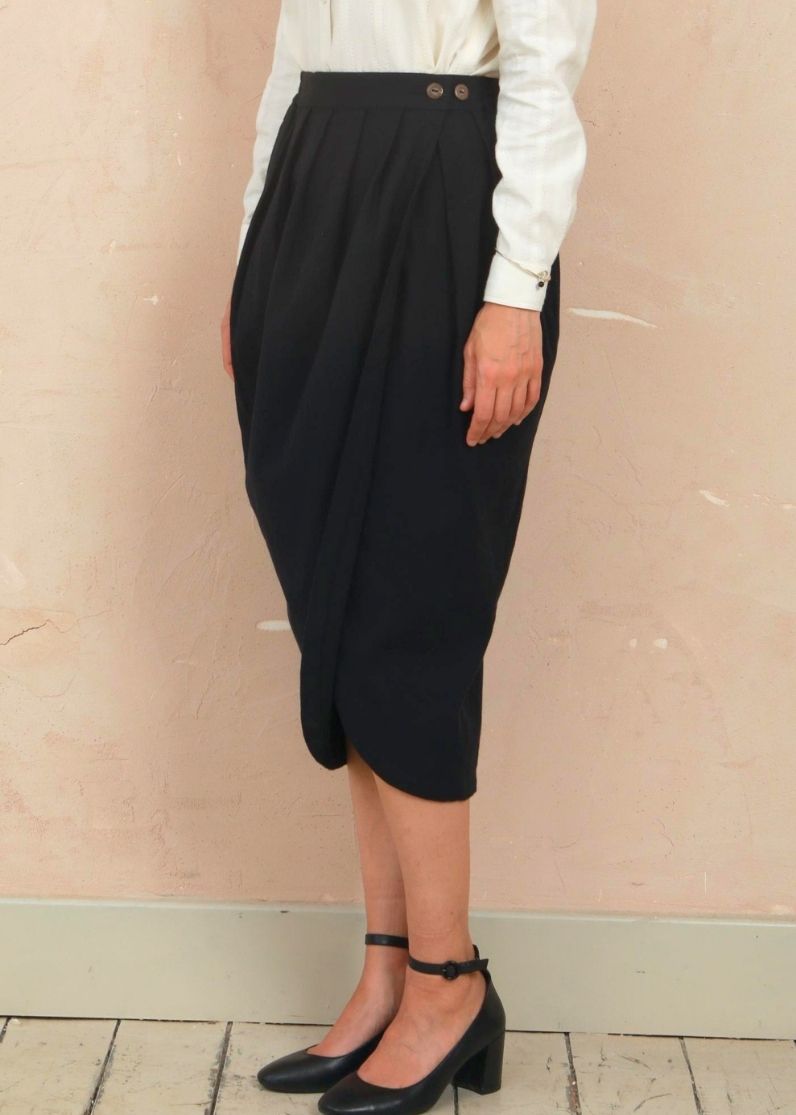 Side profile view of model wearing the black Venus Skirt showing the midi length and silhouette