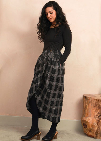 Model wearing the black Nachnakhati stitch Venus Skirt with a long-sleeve black top and heeled shoes